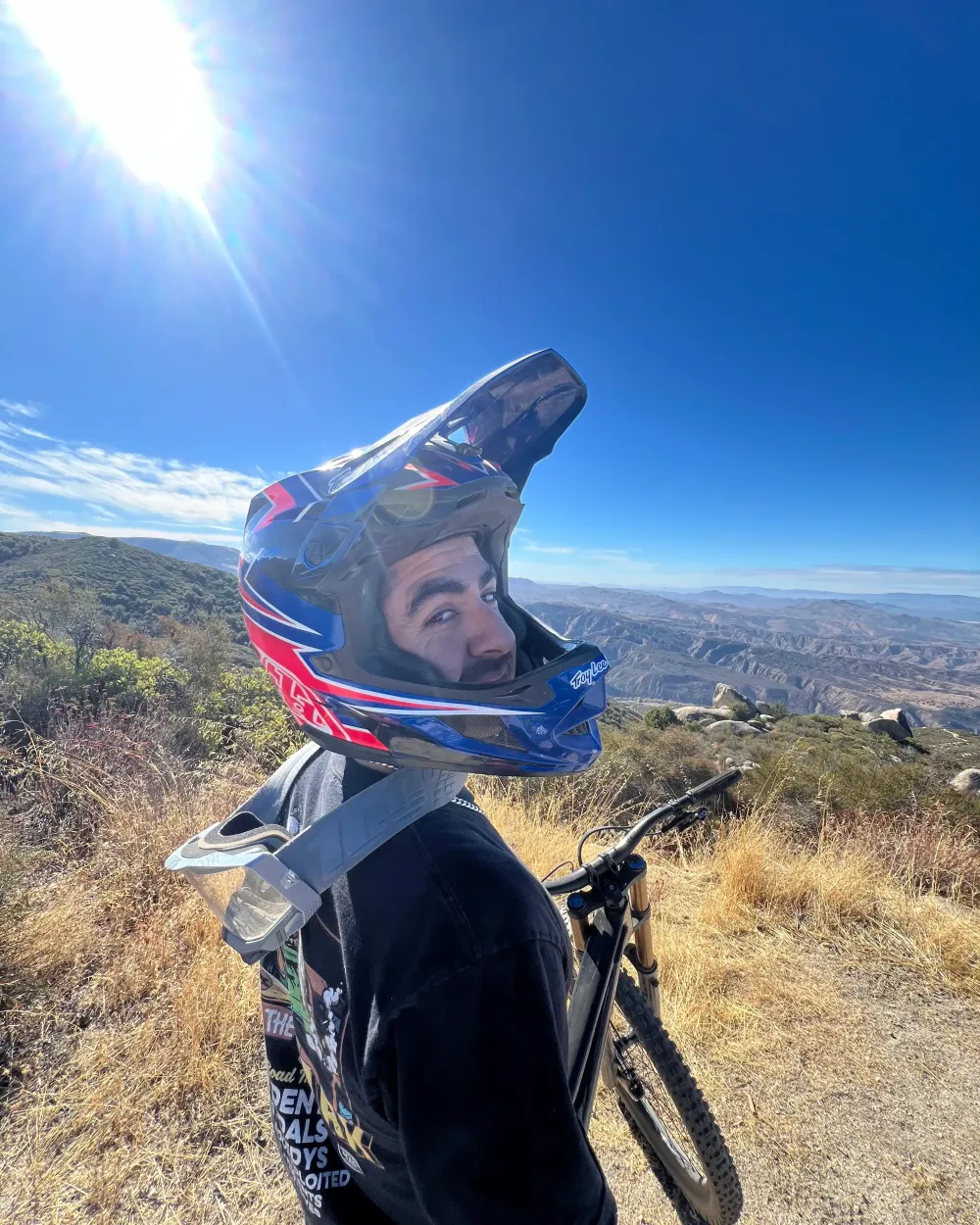 Jaime in a full-face mountain bike helmet on a ridge trail